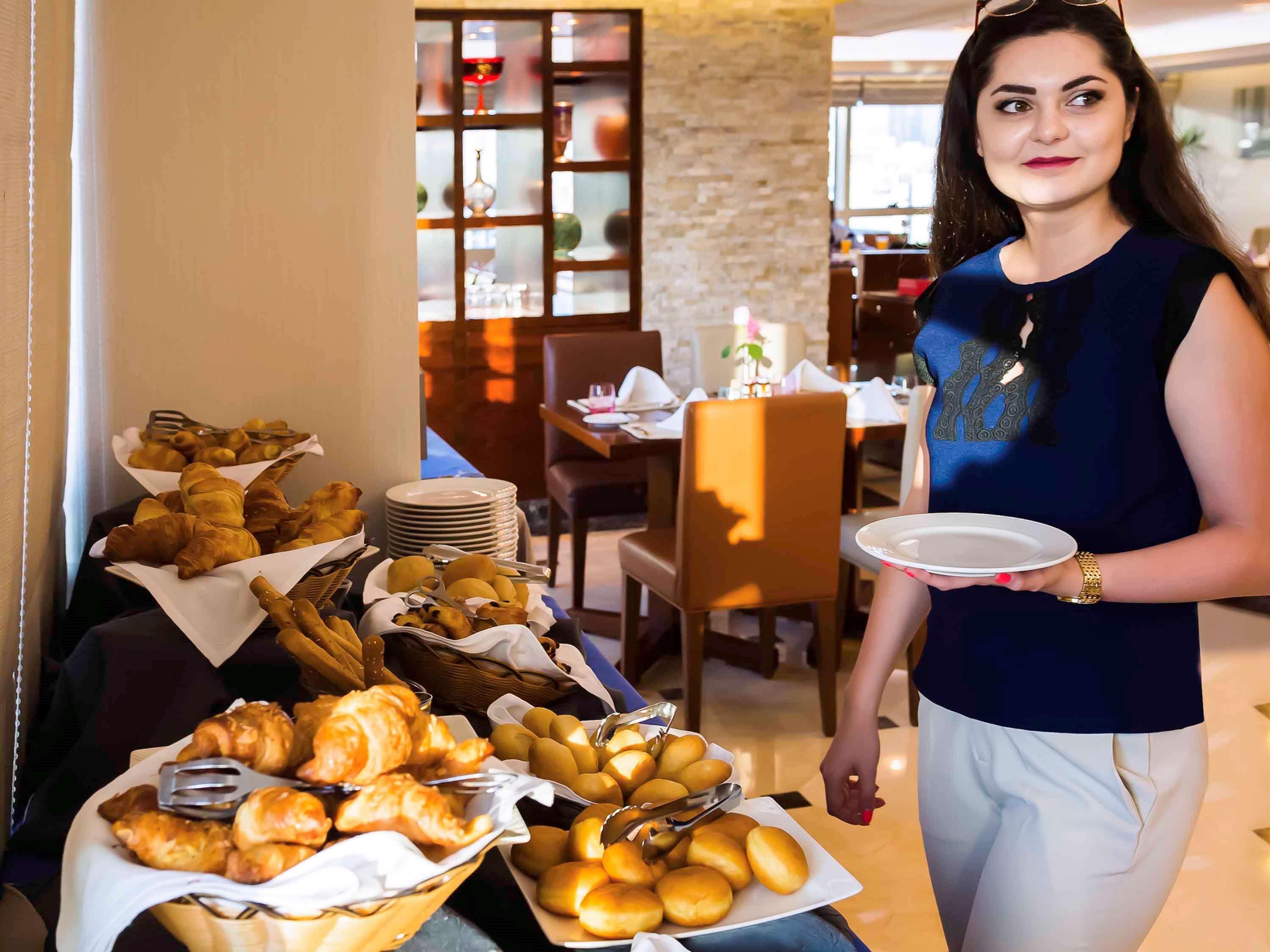 Grand Mercure Majlis Residences Abu Dhabi Exterior foto A hotel staff serving food
